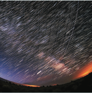 Vertical streaks across a night sky timelapse photo from the Starlink satellite constellation. Credit: National Science Foundation